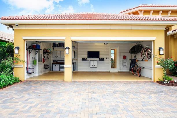 Well organized clean three car residential Garage Three car garage attached to a home in a residential community.  The garage is very neat and clean.  It is well organized with shelves, bicycle racks,a work area and storage cabinets.  It also has a flat screen tv on the wall. there are no cars in the garage.  Daytime shot taken with a Canon 5D Mark 3 camera.  rm garage stock pictures, royalty-free photos & images