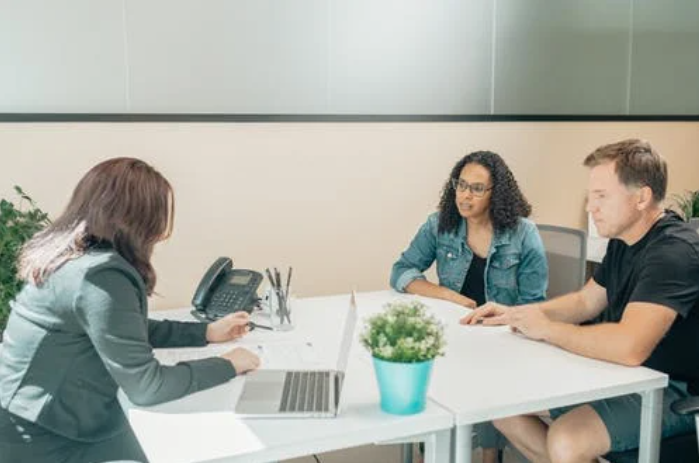 A group of people sitting around a table Description automatically generated with low confidence