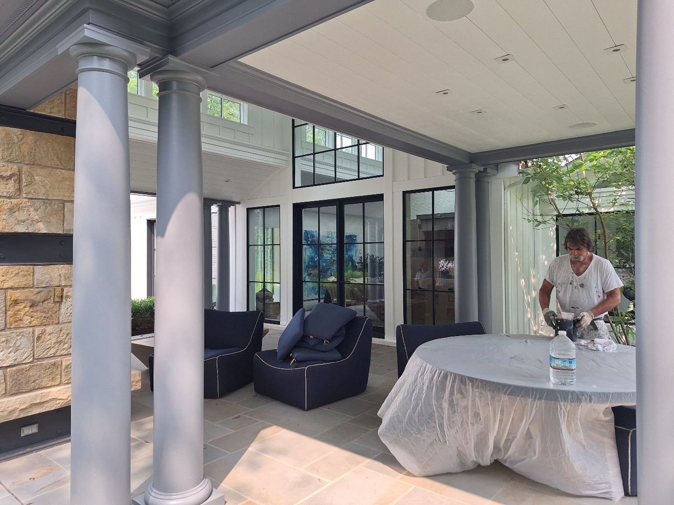 A person standing in front of a covered patio Description automatically generated